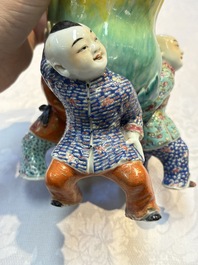A Chinese famille rose figure of three boys holding a Buddha&rsquo;s hand, Republic