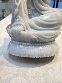 An exceptional and large Chinese carved pale lavender jadeite Guanyin on a wooden stand, Republic