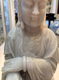 An exceptional and large Chinese carved pale lavender jadeite Guanyin on a wooden stand, Republic
