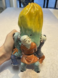 A Chinese famille rose figure of three boys holding a Buddha&rsquo;s hand, Republic