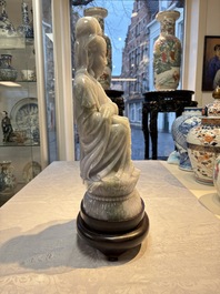 An exceptional and large Chinese carved pale lavender jadeite Guanyin on a wooden stand, Republic
