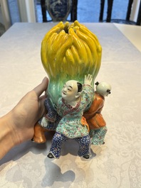 A Chinese famille rose figure of three boys holding a Buddha&rsquo;s hand, Republic