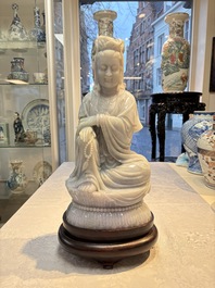 An exceptional and large Chinese carved pale lavender jadeite Guanyin on a wooden stand, Republic