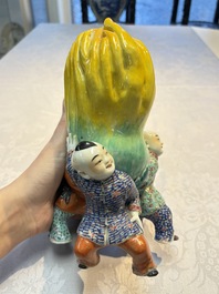 A Chinese famille rose figure of three boys holding a Buddha&rsquo;s hand, Republic