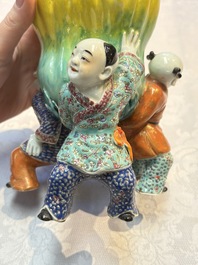 A Chinese famille rose figure of three boys holding a Buddha&rsquo;s hand, Republic