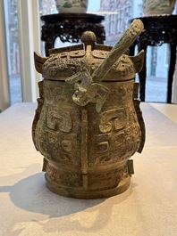 A Chinese archaic bronze wine vessel and cover with Taotie design, You 卣, late Shang