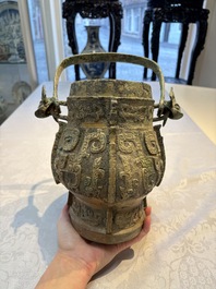 A Chinese archaic bronze wine vessel and cover with Taotie design, You 卣, late Shang