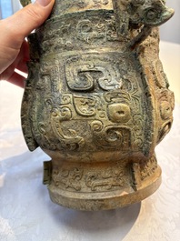 A Chinese archaic bronze wine vessel and cover with Taotie design, You 卣, late Shang