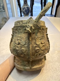 A Chinese archaic bronze wine vessel and cover with Taotie design, You 卣, late Shang
