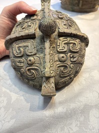 A Chinese archaic bronze wine vessel and cover with Taotie design, You 卣, late Shang