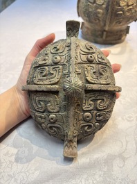 A Chinese archaic bronze wine vessel and cover with Taotie design, You 卣, late Shang