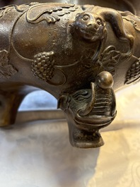 A rare Chinese bronze tripod censer with relief mythical animal and grape design, Xuande mark, 19th C.