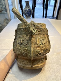 A Chinese archaic bronze wine vessel and cover with Taotie design, You 卣, late Shang