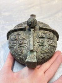 A Chinese archaic bronze wine vessel and cover with Taotie design, You 卣, late Shang