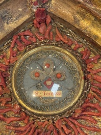 An Italian carved wood and coral- and turquoise-decorated reliquary containing a relic ex cineribus of Saint Teresa of Jesus, early 20th C.