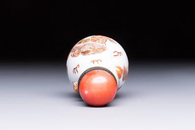 A Chinese gilt-decorated iron-red 'Buddhist Lions' snuff bottle with a red coral stopper, Buddhist Lion mark, Republic
