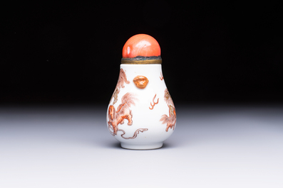 A Chinese gilt-decorated iron-red 'Buddhist Lions' snuff bottle with a red coral stopper, Buddhist Lion mark, Republic