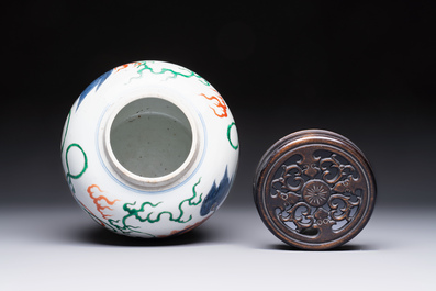A fine Chinese famille verte 'Buddhist Lions' jar and a reticulated wooden cover, 19th C.