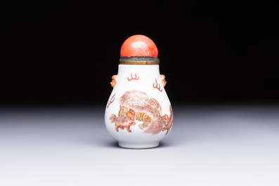 A Chinese gilt-decorated iron-red 'Buddhist Lions' snuff bottle with a red coral stopper, Buddhist Lion mark, Republic