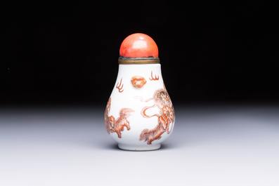 A Chinese gilt-decorated iron-red 'Buddhist Lions' snuff bottle with a red coral stopper, Buddhist Lion mark, Republic