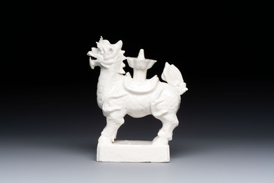 A Chinese Dehua blanc de Chine candlestick in the form a qilin, Kangxi