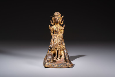 A Thai gilt-bronze figure of a seated deity with attendant animals, 19th C.