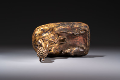 A Thai gilt-bronze figure of a seated deity with attendant animals, 19th C.