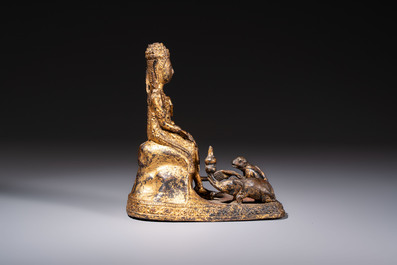 A Thai gilt-bronze figure of a seated deity with attendant animals, 19th C.