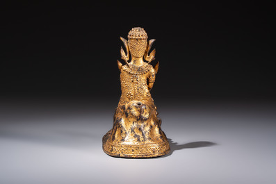 A Thai gilt-bronze figure of a seated deity with attendant animals, 19th C.