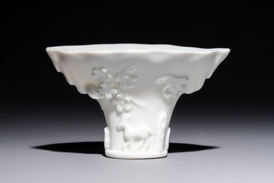 A Chinese Dehua blanc de Chine 'Dragon, Carp, Crane and Deer' libation cup, Kangxi