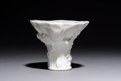 A Chinese Dehua blanc de Chine 'Dragon, Carp, Crane and Deer' libation cup, Kangxi