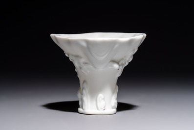 A Chinese Dehua blanc de Chine 'Dragon, Carp, Crane and Deer' libation cup, Kangxi