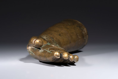 A rare and large Tibetan bronze forearm of a Buddhist figure with a chakra design, on a later metal stand, Qing