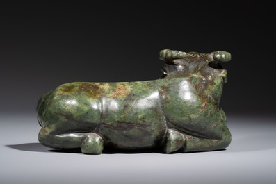 A Chinese green jade reclining buffalo on a wooden stand, 19/20th C.