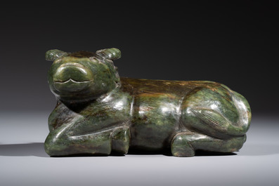 A Chinese green jade reclining buffalo on a wooden stand, 19/20th C.