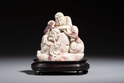A Chinese stone group of 'Luohan' on wooden stand, Republic