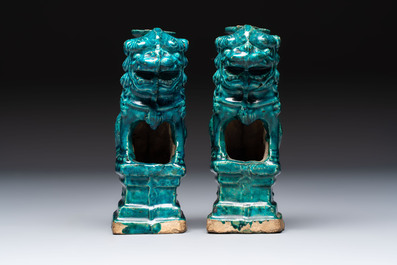 A pair of Chinese turquoise-glazed lion-shaped joss stick holders on wooden stands, Ming