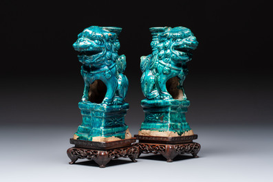 A pair of Chinese turquoise-glazed lion-shaped joss stick holders on wooden stands, Ming