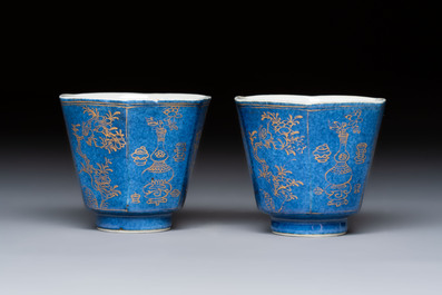 A pair of Chinese gilt-decorated powder-blue-ground 'Antiquities' cups and saucers, lingzhi mark, Kangxi