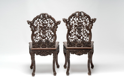 A pair of richly carved Chinese hongmu 'Dragon' chairs with cane seats, 19th C.