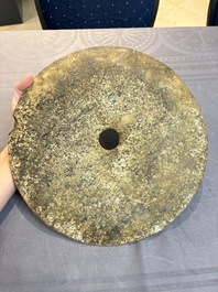 A Chinese archaic calcified jade 'bi' disc on an iron stand, possibly Zhou