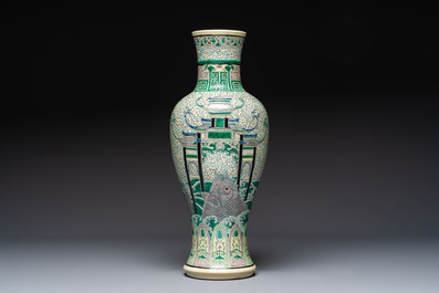 A Chinese verte biscuit 'Dragon Gate Carp 鯉躍龍門' vase on a wooden stand, Xuande mark, 19th C.