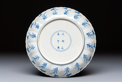 A Chinese blue and white 'Elegant Lady with Two Boys' plate with a 'Lotus Scroll' border, Kangxi