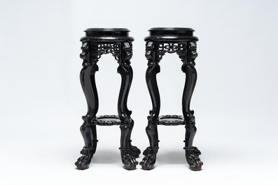 A pair of black-lacquered carved wood chinoiserie stands on lion feet, 19th C.