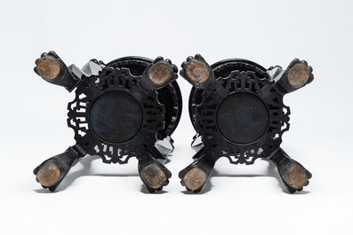 A pair of black-lacquered carved wood chinoiserie stands on lion feet, 19th C.