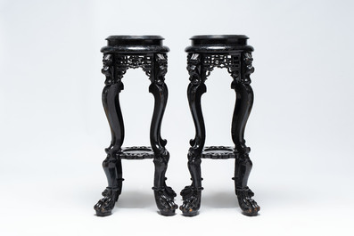 A pair of black-lacquered carved wood chinoiserie stands on lion feet, 19th C.
