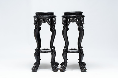 A pair of black-lacquered carved wood chinoiserie stands on lion feet, 19th C.