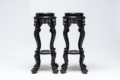 A pair of black-lacquered carved wood chinoiserie stands on lion feet, 19th C.