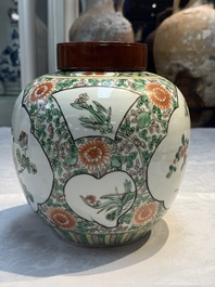 A pair of Chinese famille verte 'Floral' jars with wooden covers, 19th C.