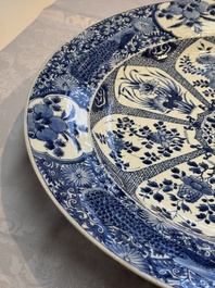 A pair of large Chinese blue and white 'Peacock Border' chargers with floral design, Kangxi